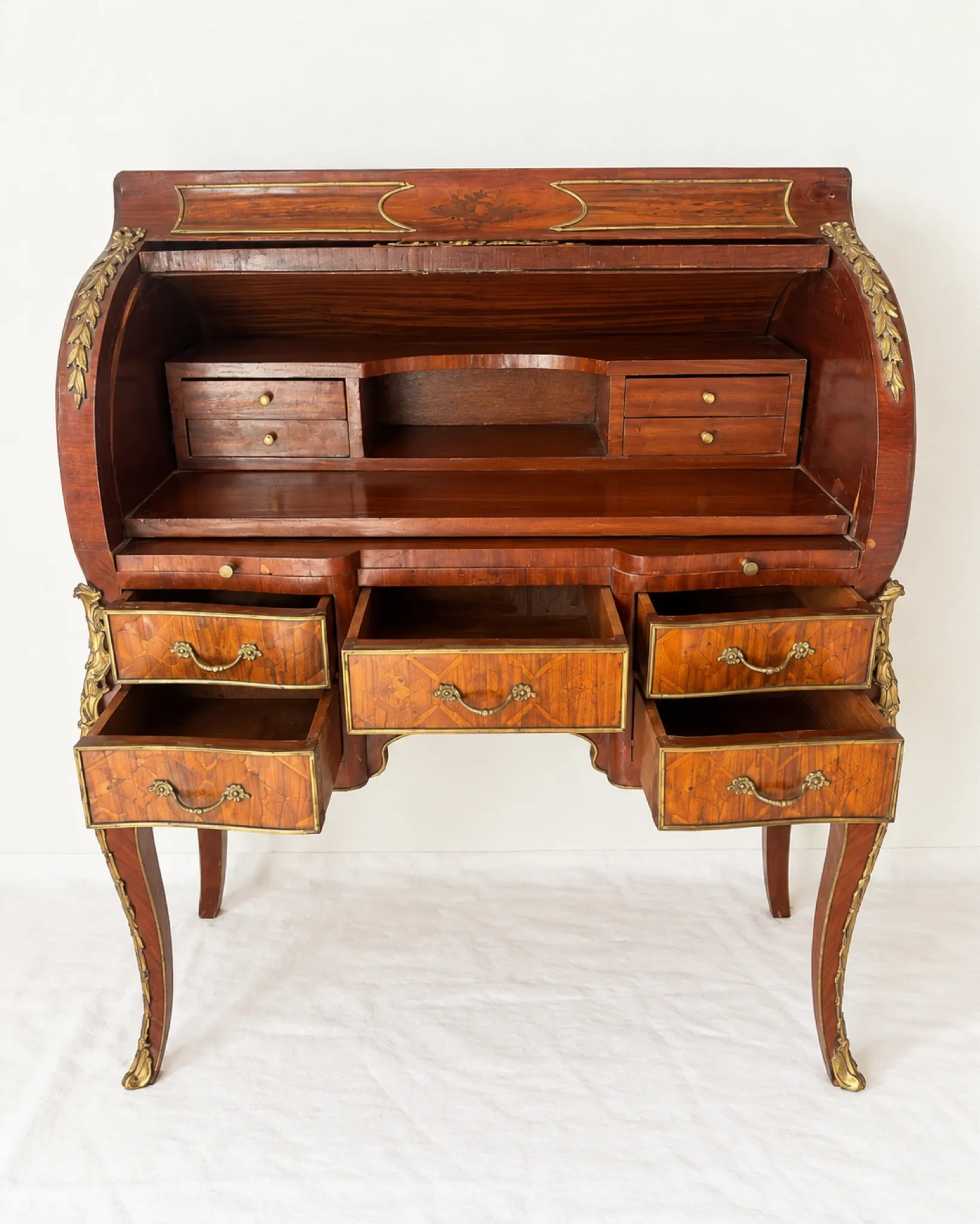Louis XV cylinder desk with floral marquetry and gilded ornaments.