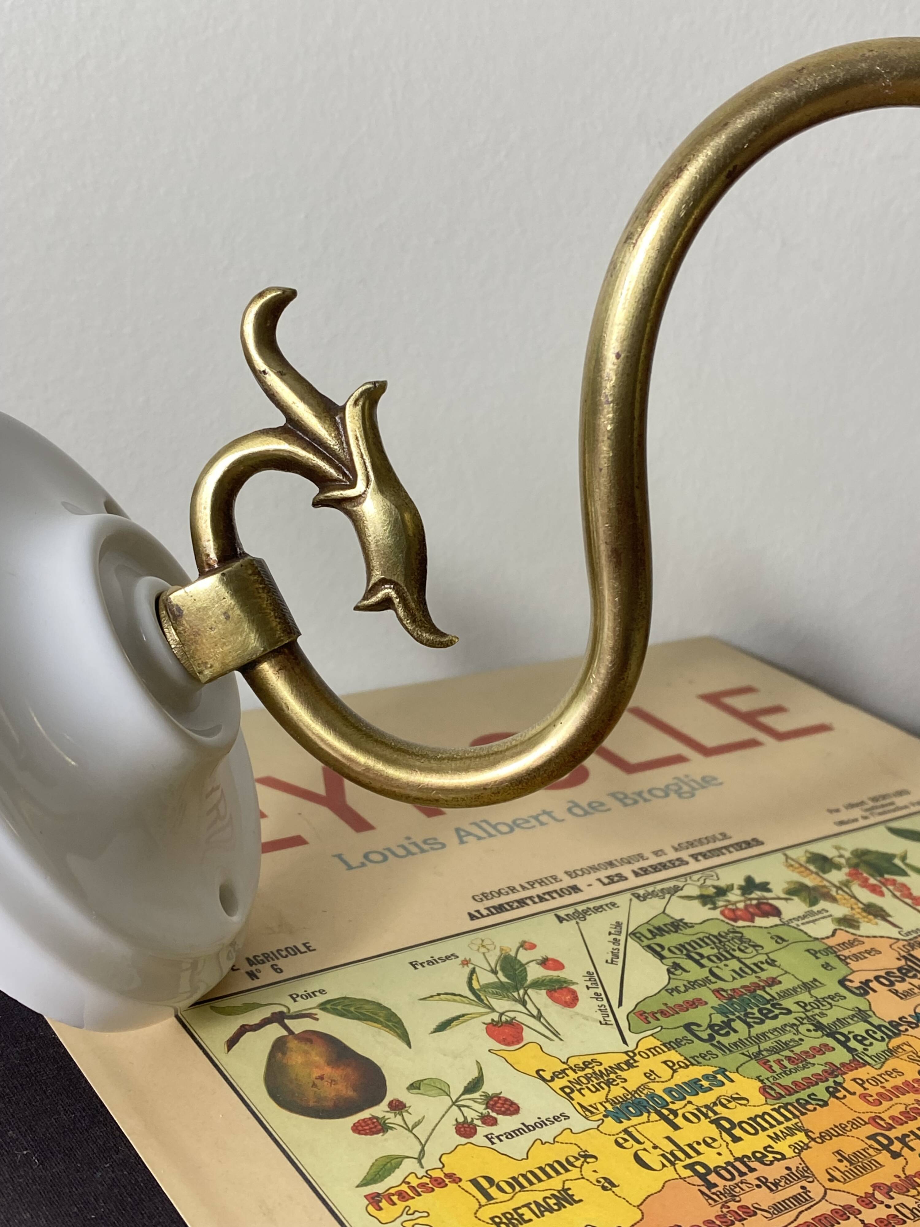 Swan neck wall light in brass with rose petal glass shade.