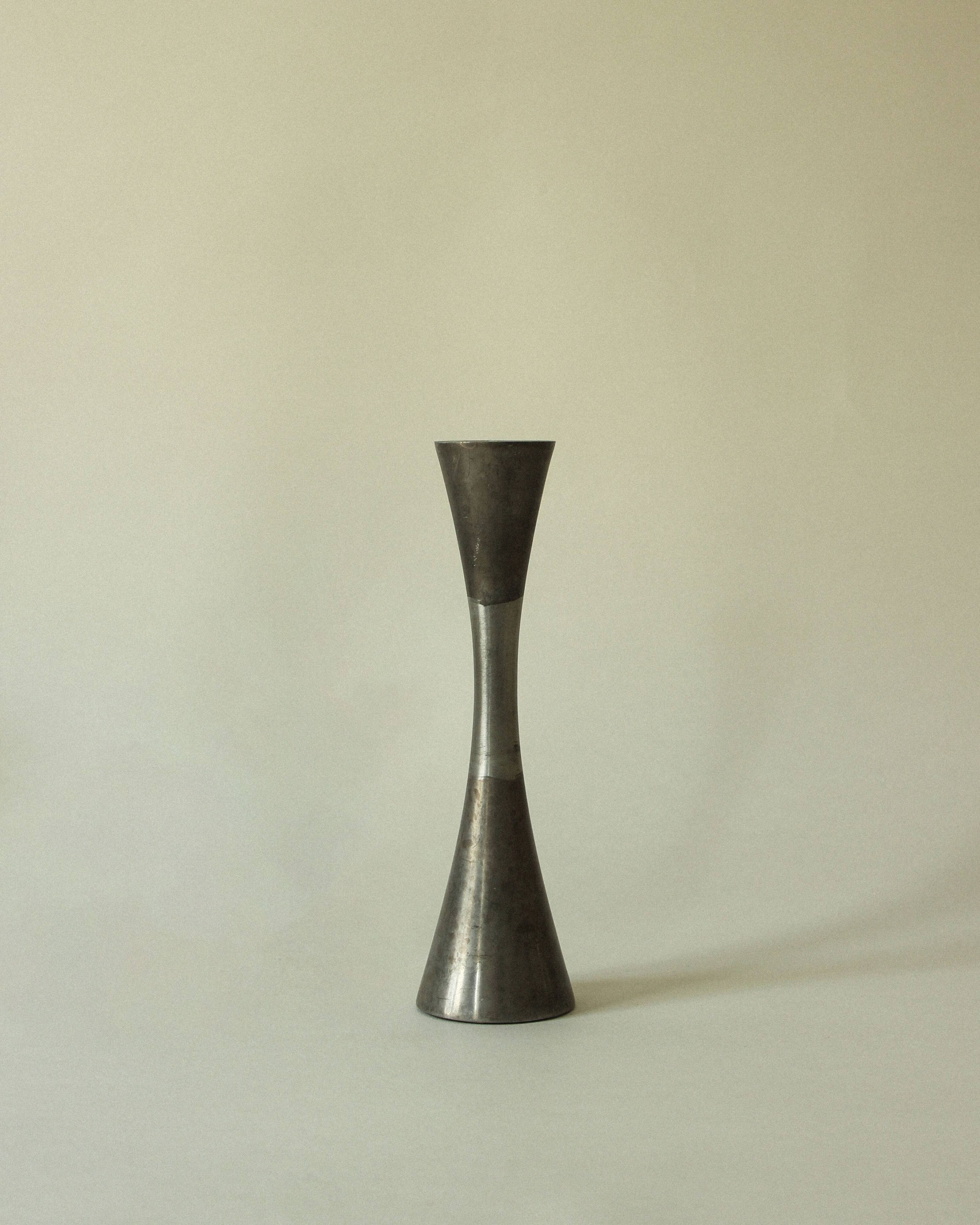 Set of three diabolo-shaped candle holders made of cast steel.