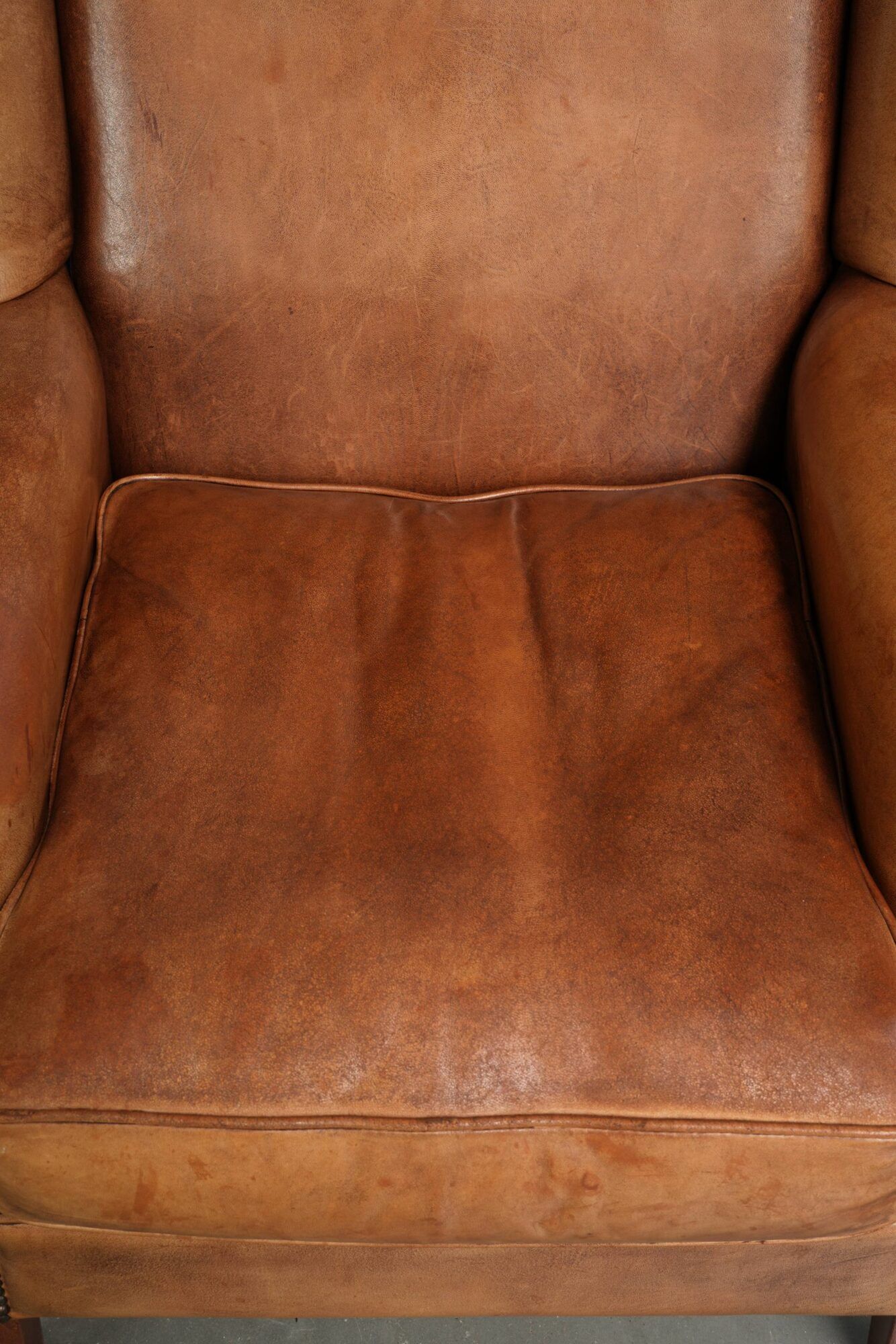 Sheepskin wingback armchair in a light cognac colour in English style