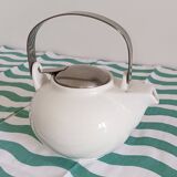 White porcelain teapot. Shiny stainless steel handle and lid
