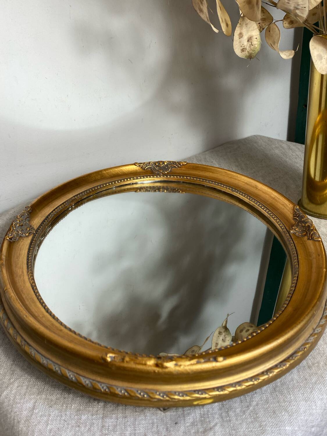 Oval-shaped gilded wooden mirror