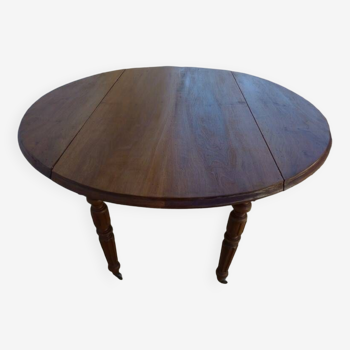 Old round table with walnut wood shutters on casters