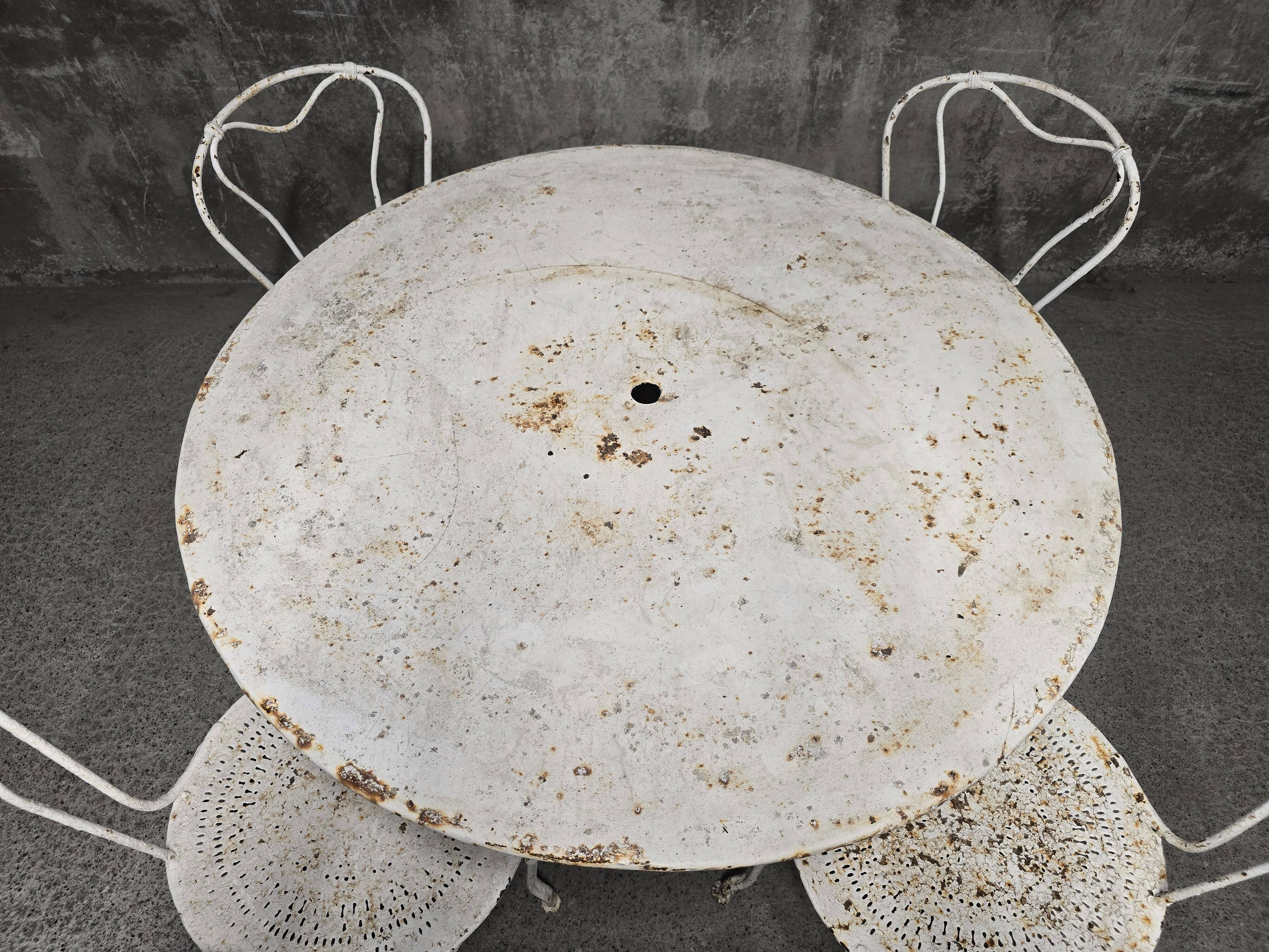 Antique painted wrought iron garden furniture, round table and four chairs.