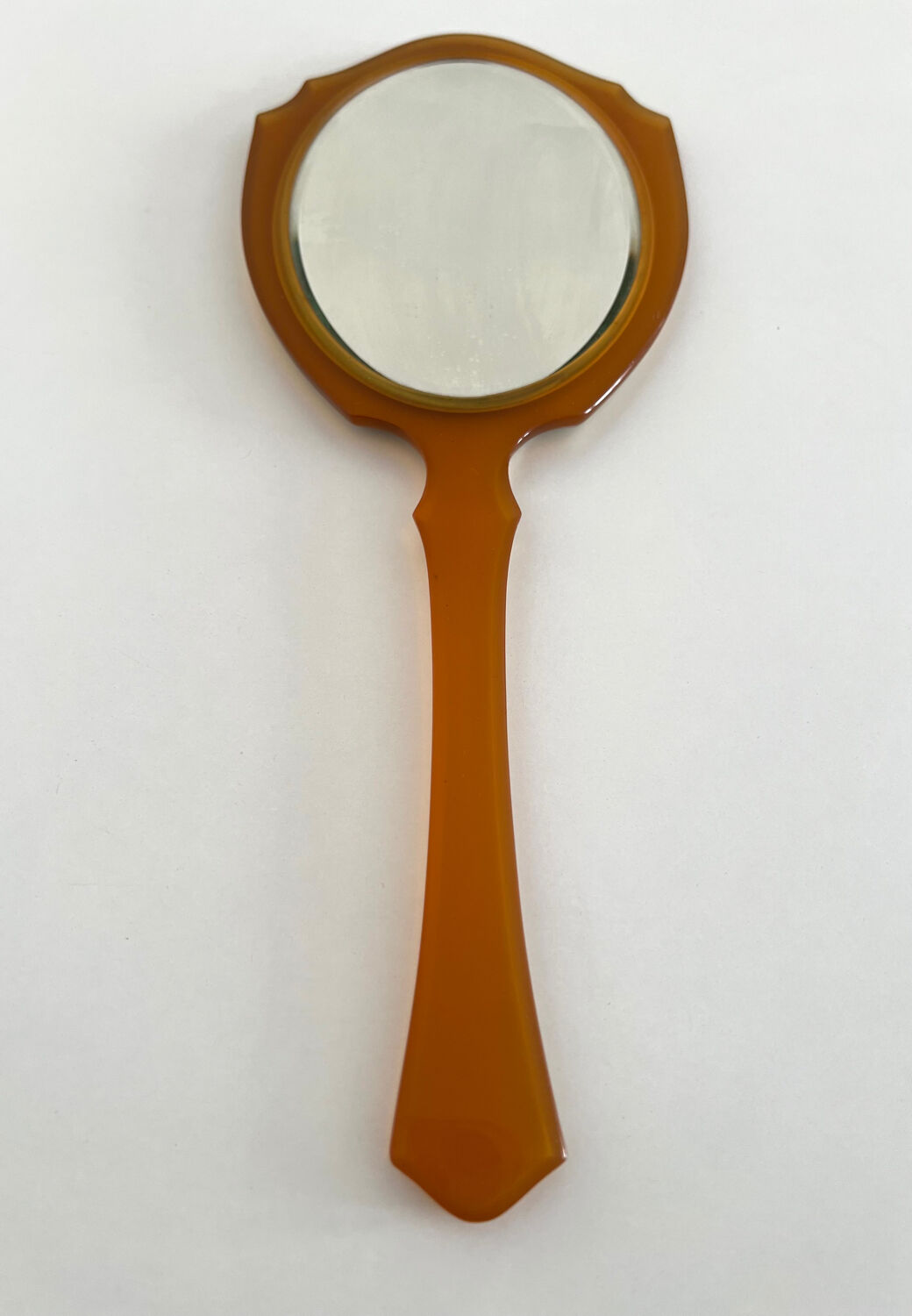 Chic coral orange hand mirror with a mother-of-pearl back – elegant retro style.