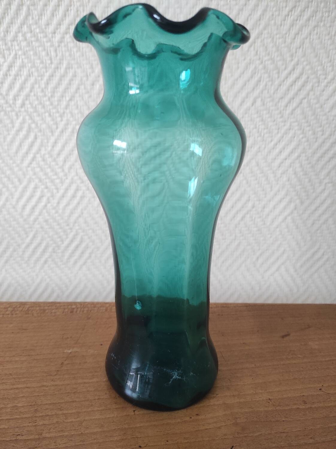 Blown glass vase with a flared neck and wavy rim.