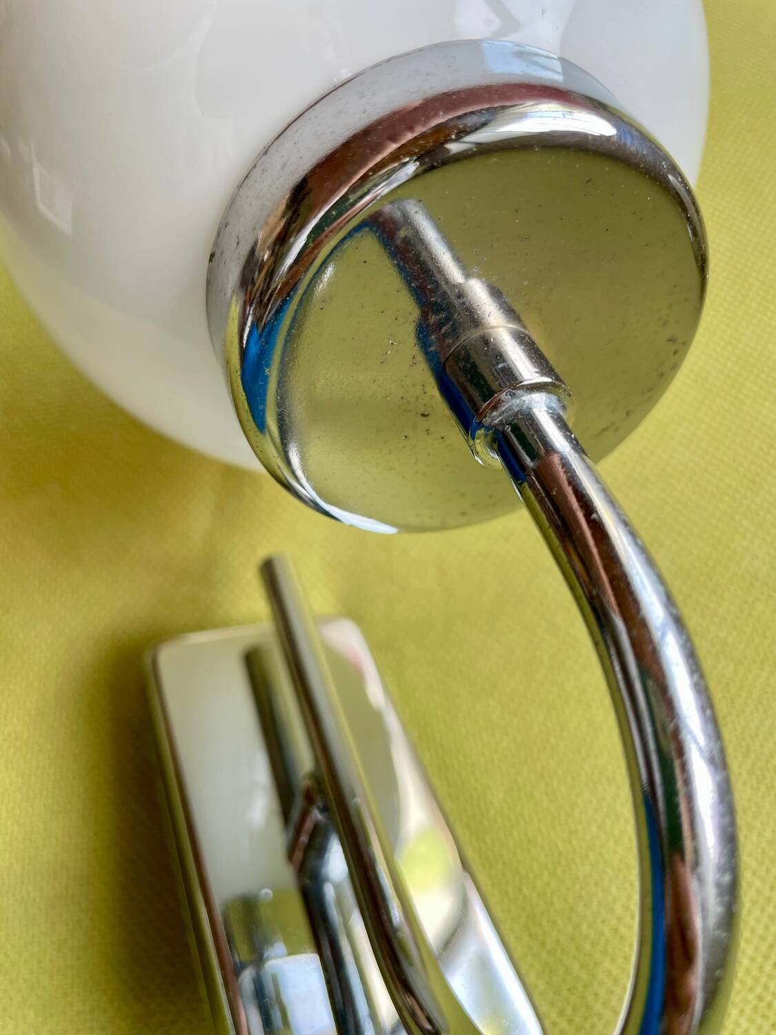Pair of chrome metal wall lights with white glass globe.