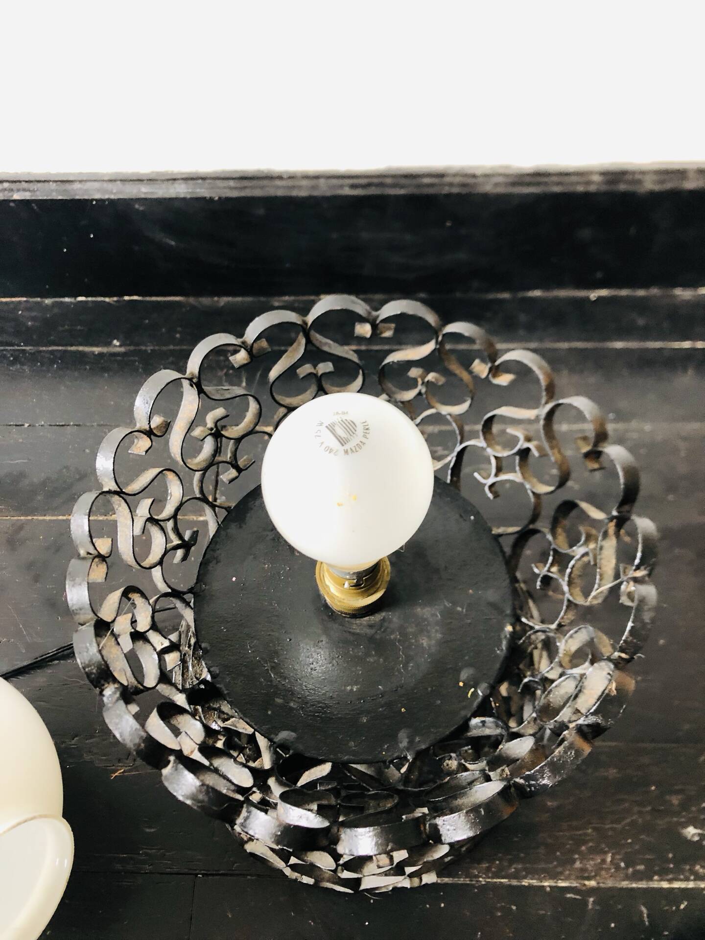 Handcrafted wrought iron lamp with a white opaline globe.