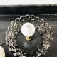 Handcrafted wrought iron lamp with a white opaline globe.