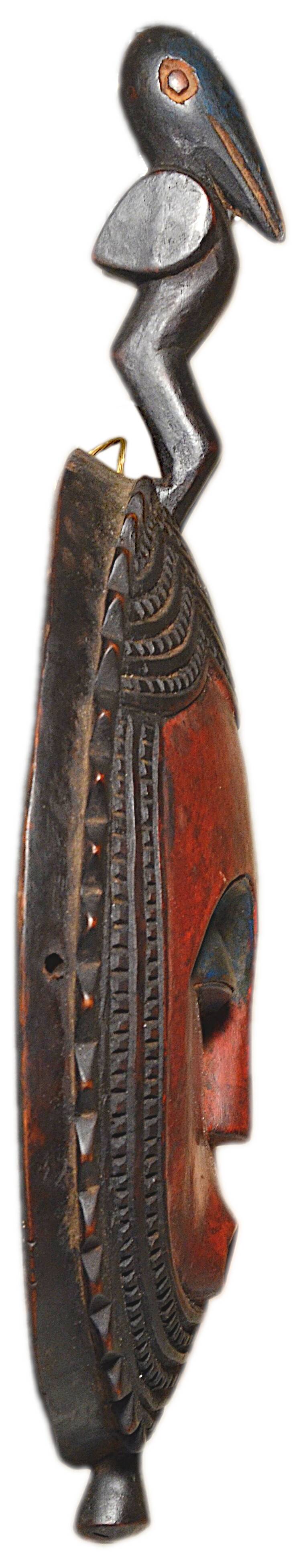 African wooden mask, face topped with a bird.