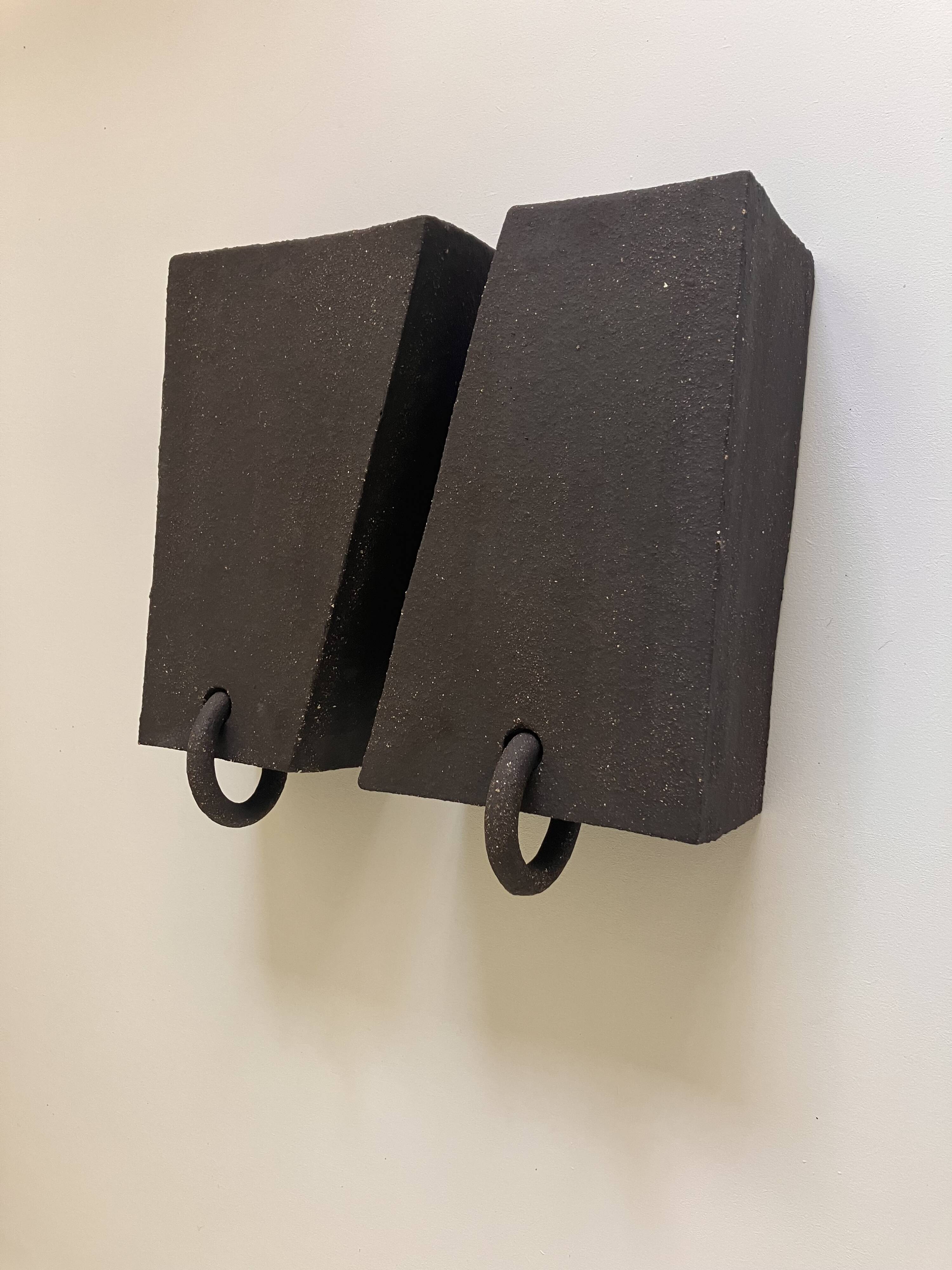 Pair of black stoneware graphic wall lights with handmade ring.