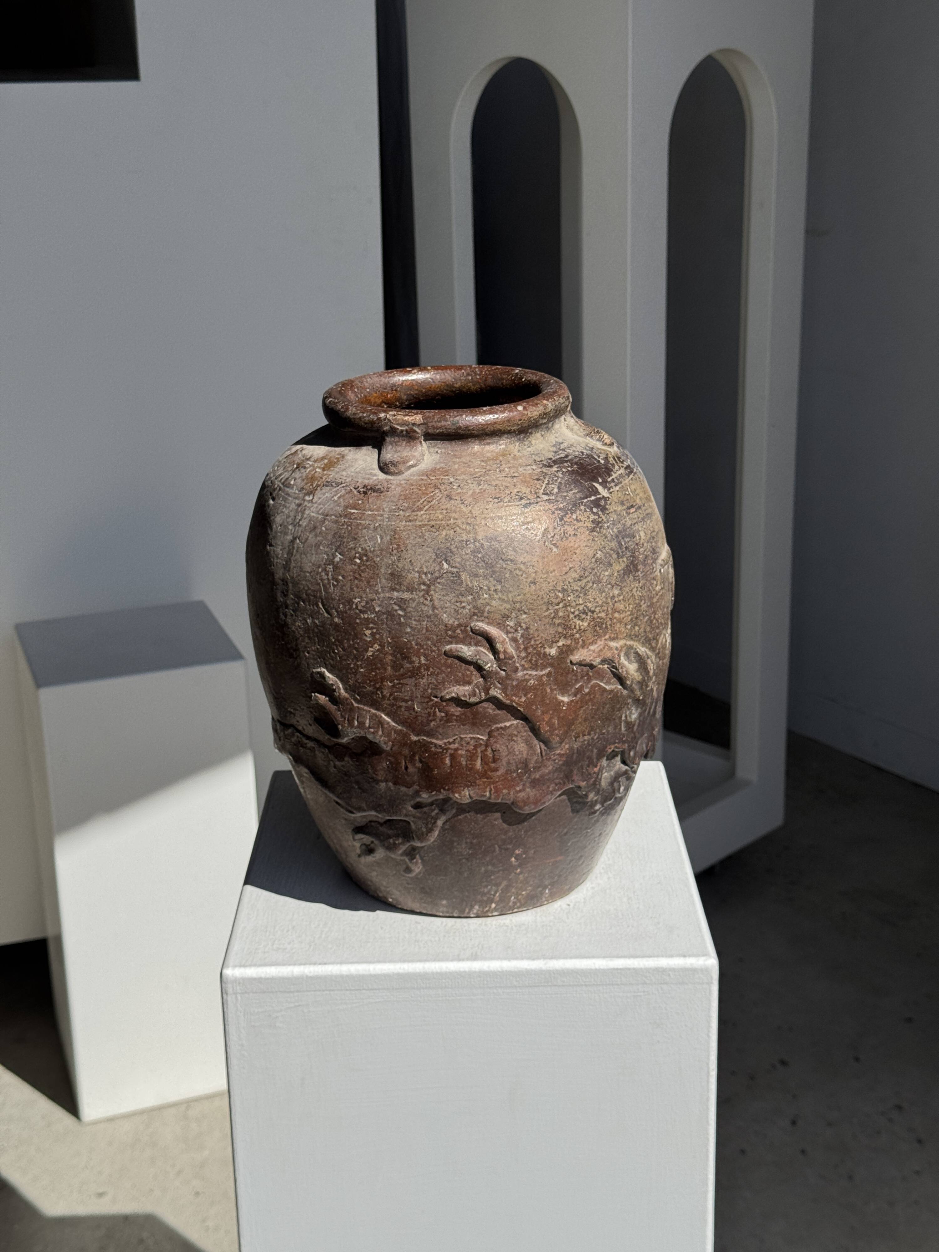 Large traditional Indonesian clay pot featuring a dragon.