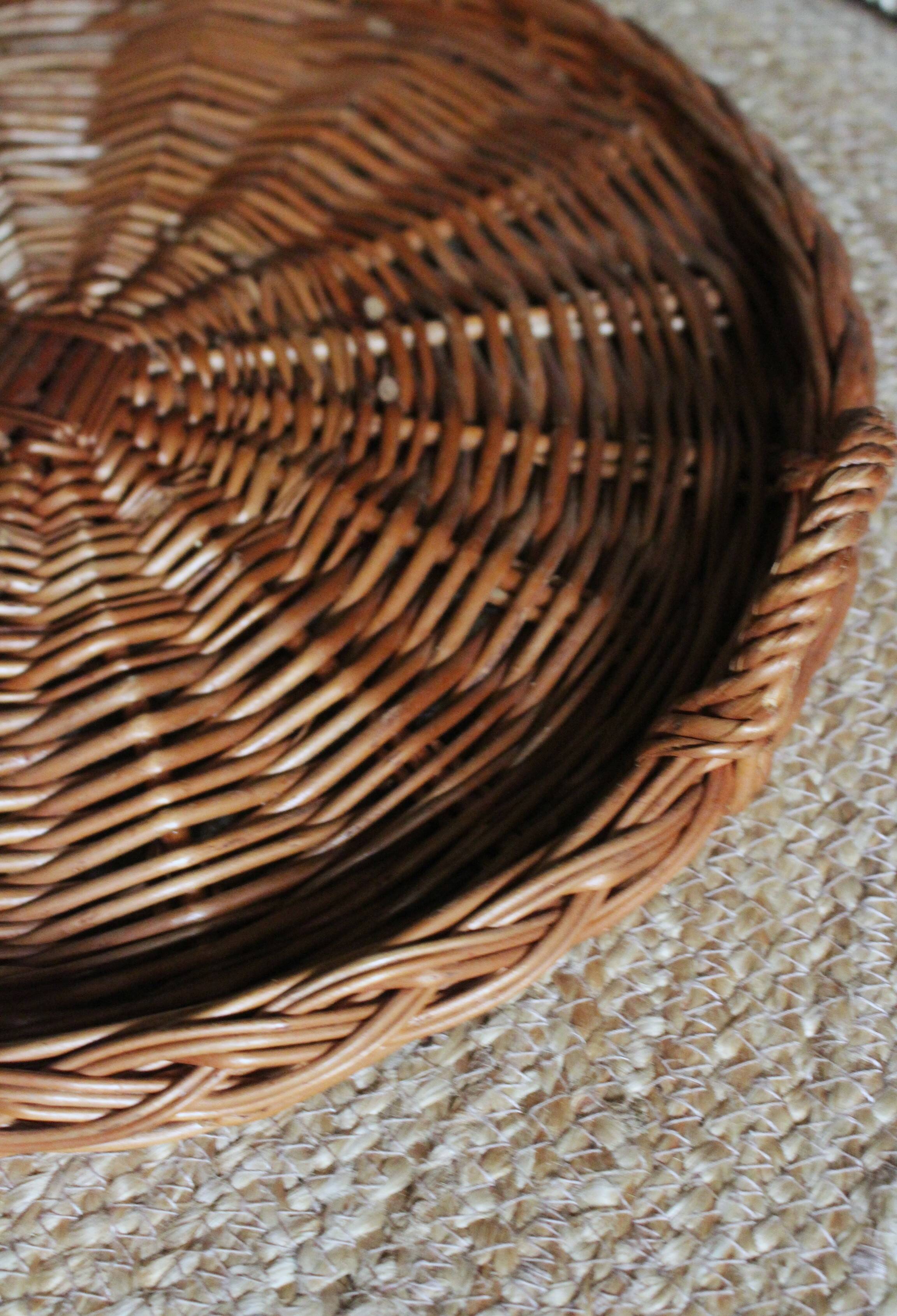 Large round dark wicker tray with two handles.
