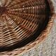 Large round dark wicker tray with two handles.