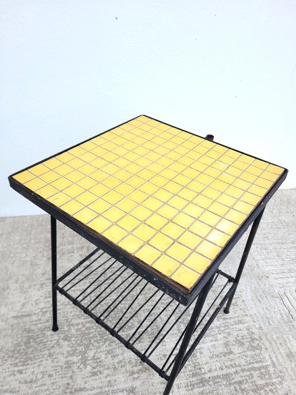 Small vintage yellow side table with magazine rack.