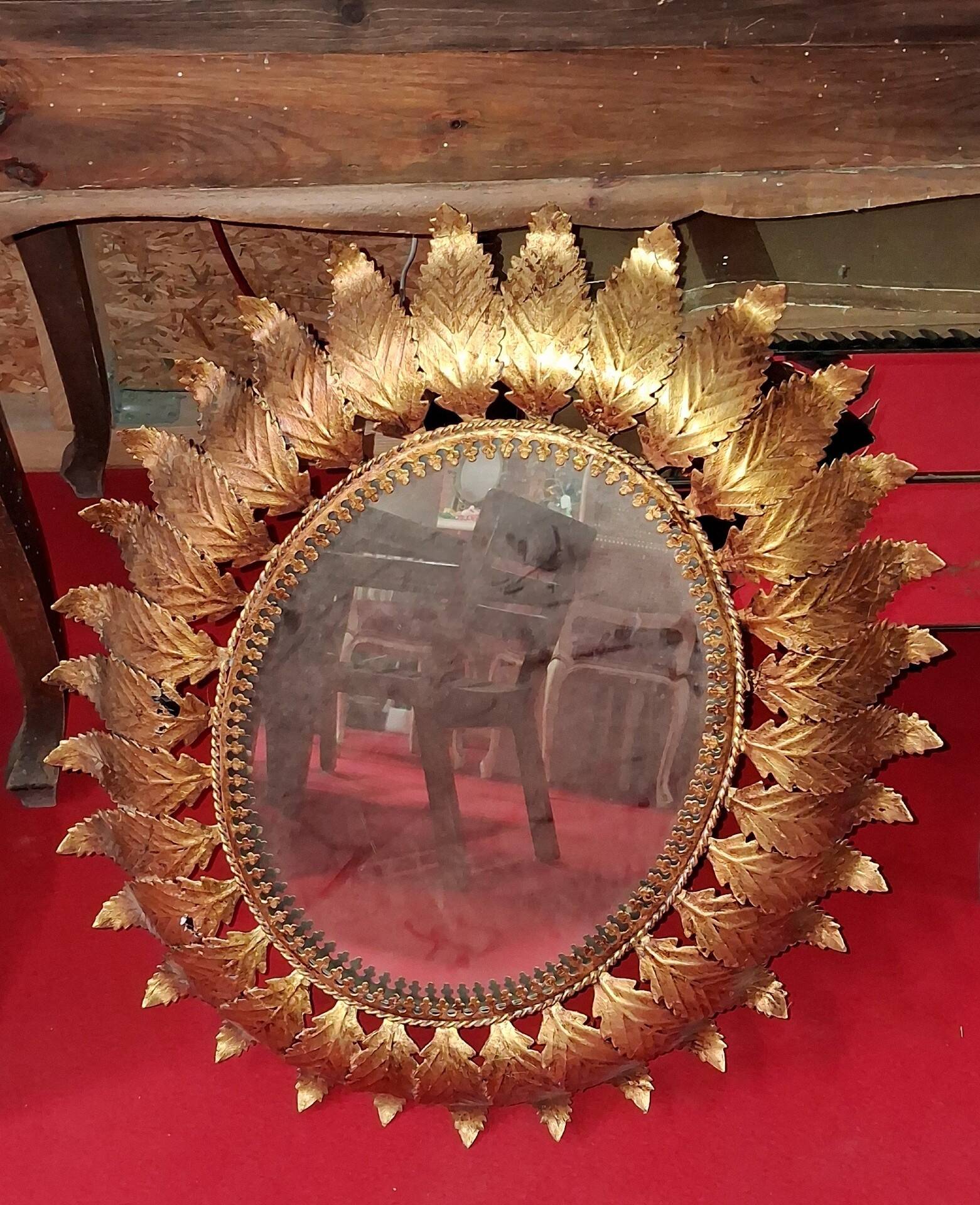 Golden metal sun mirror with leaf decoration
