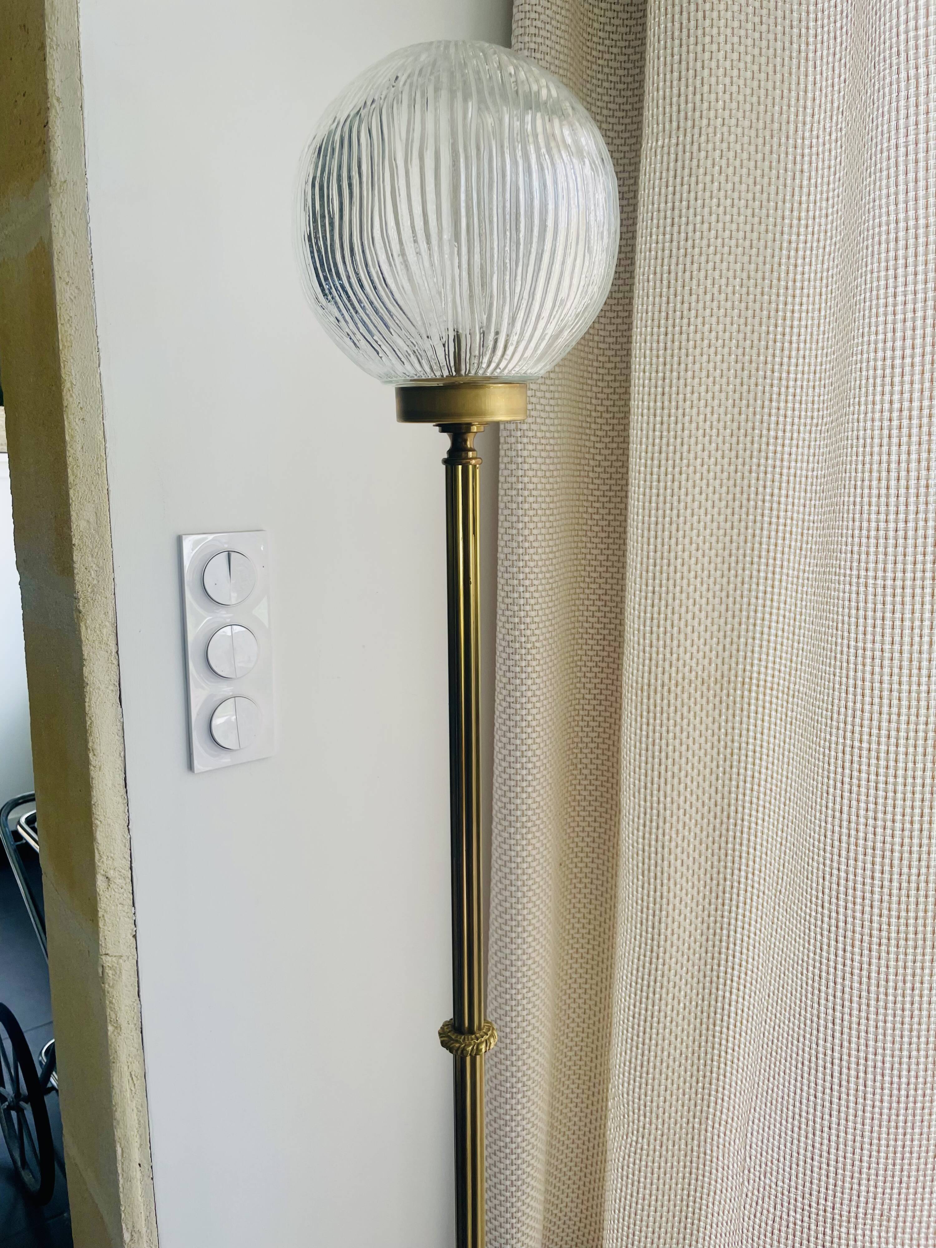 Floor lamp in gilded brass and round glass globe