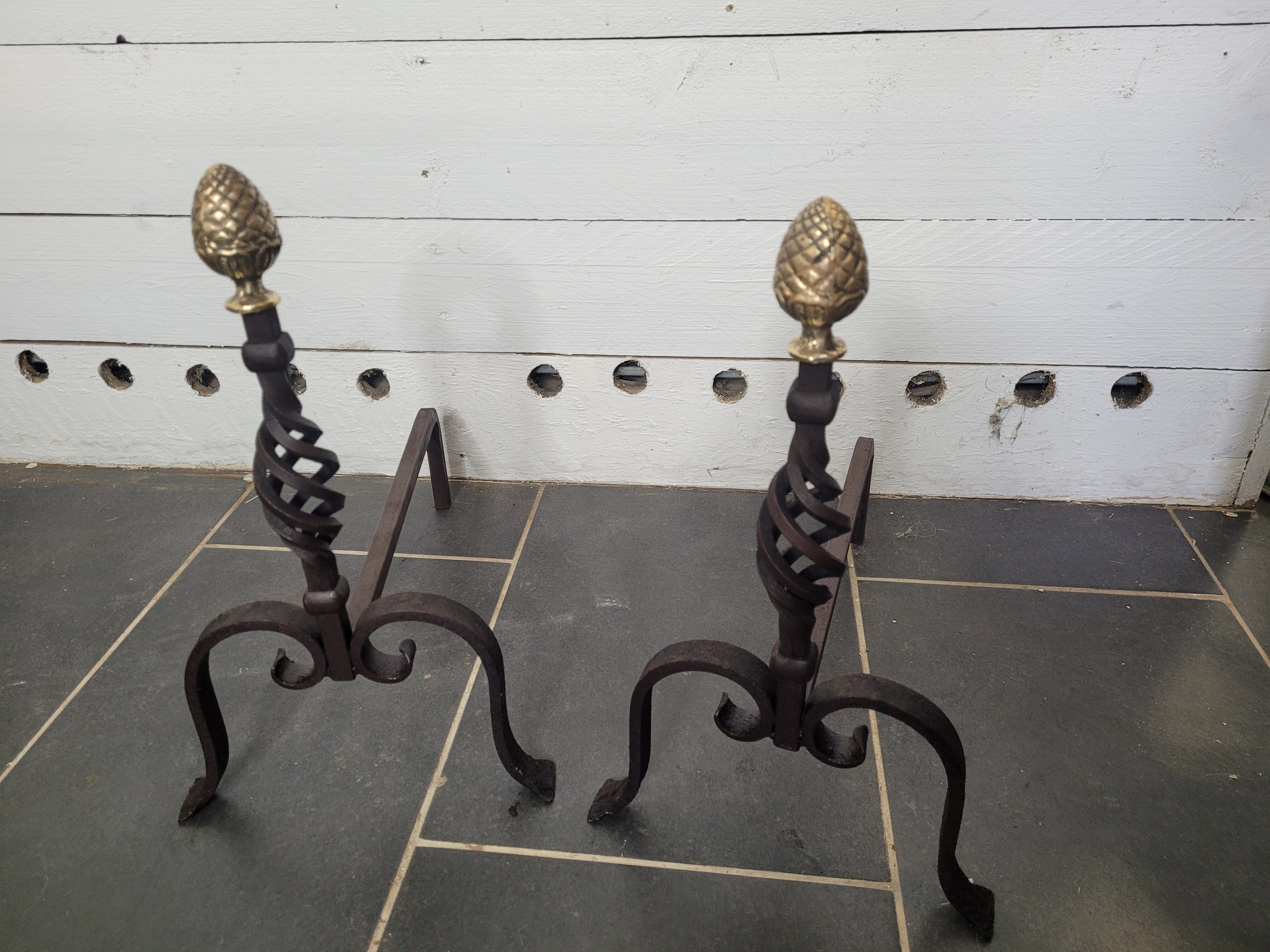 Old pair of wrought iron pegs with brass pine cone