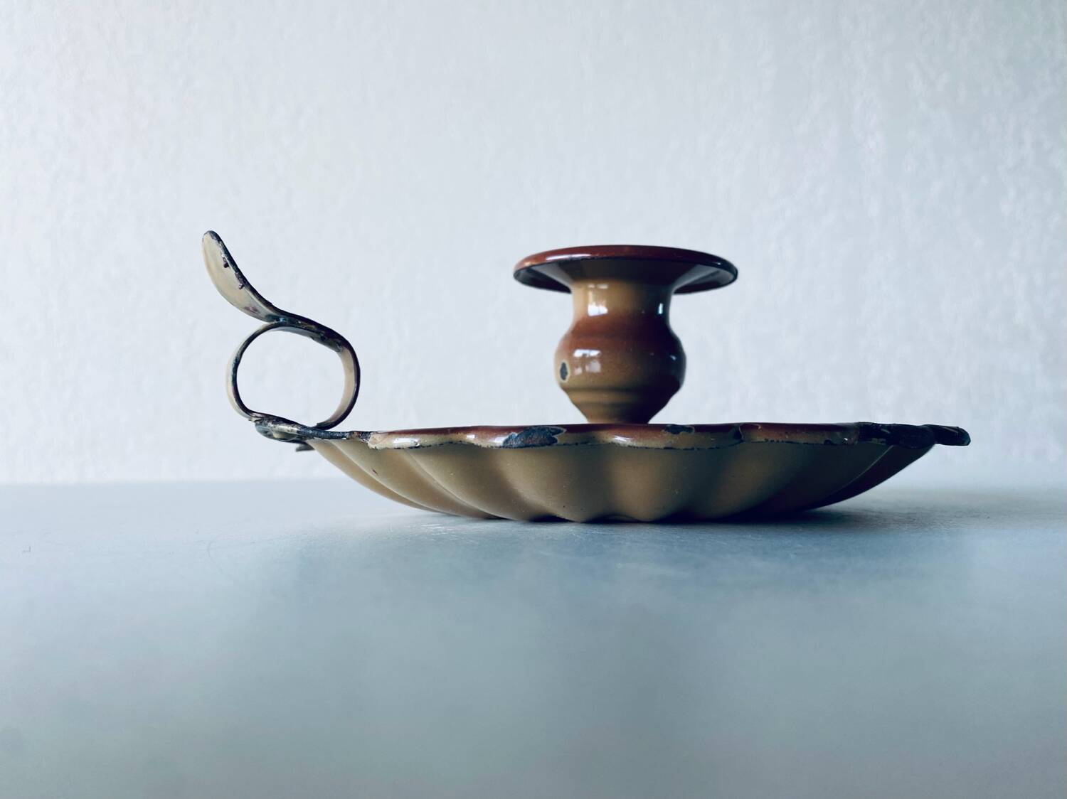 Old candle holder in brown enameled metal