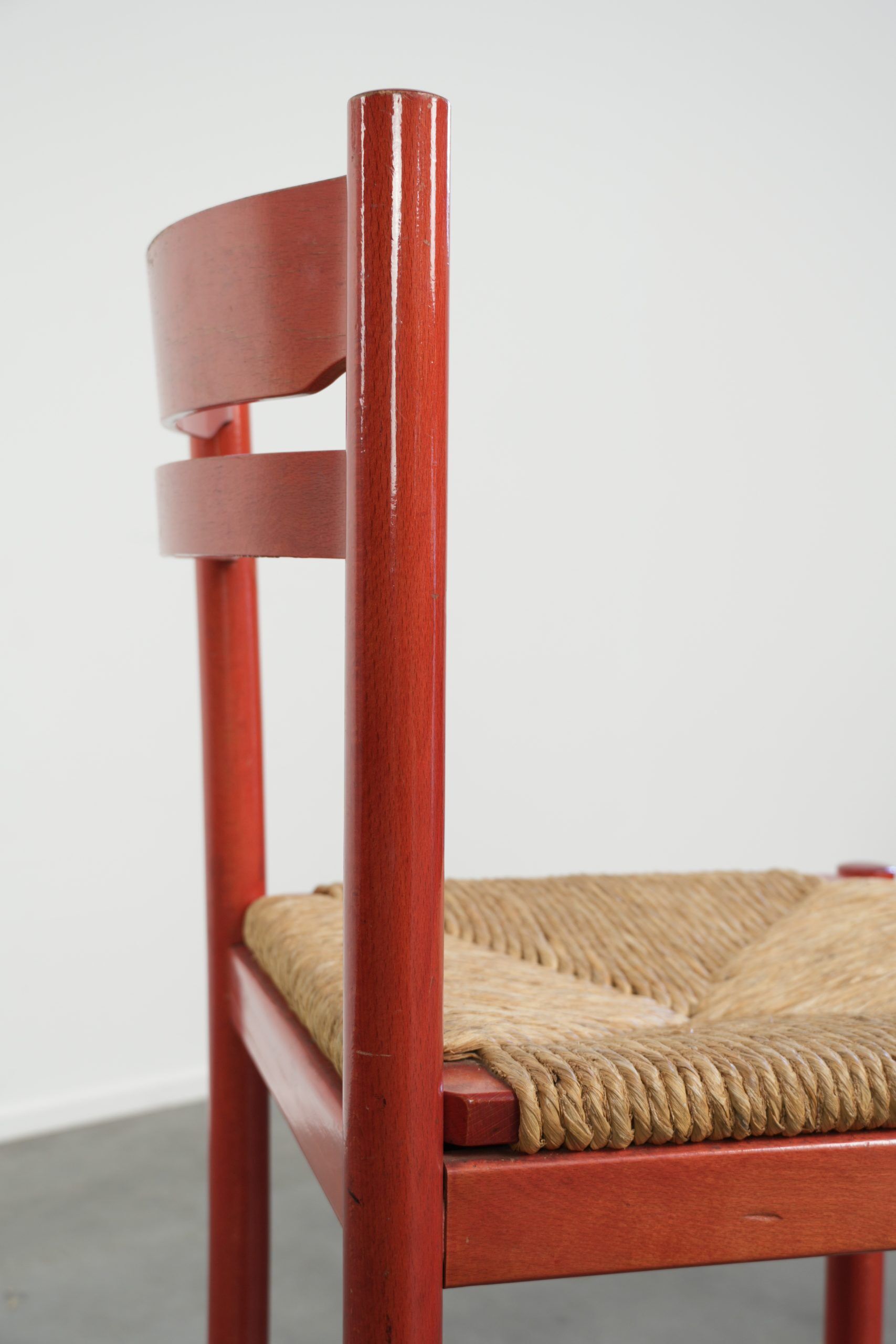 Red vintage wooden chair from the 1970s with a woven wicker seat