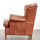 Fauteuil anglais à oreilles de couleur cognac clair en cuir de vache.