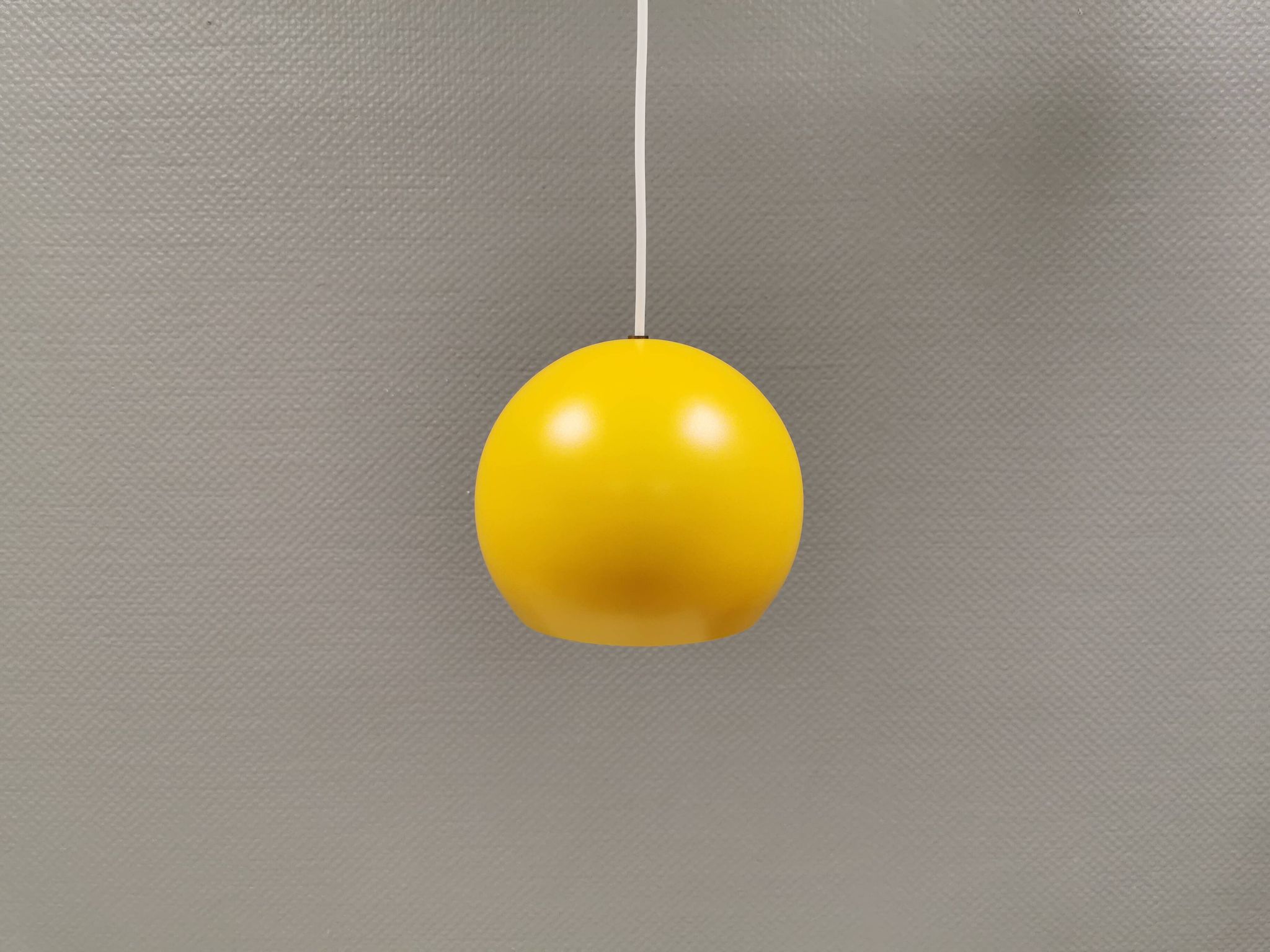 Lampe suspendue sphérique en jaune ensoleillé.