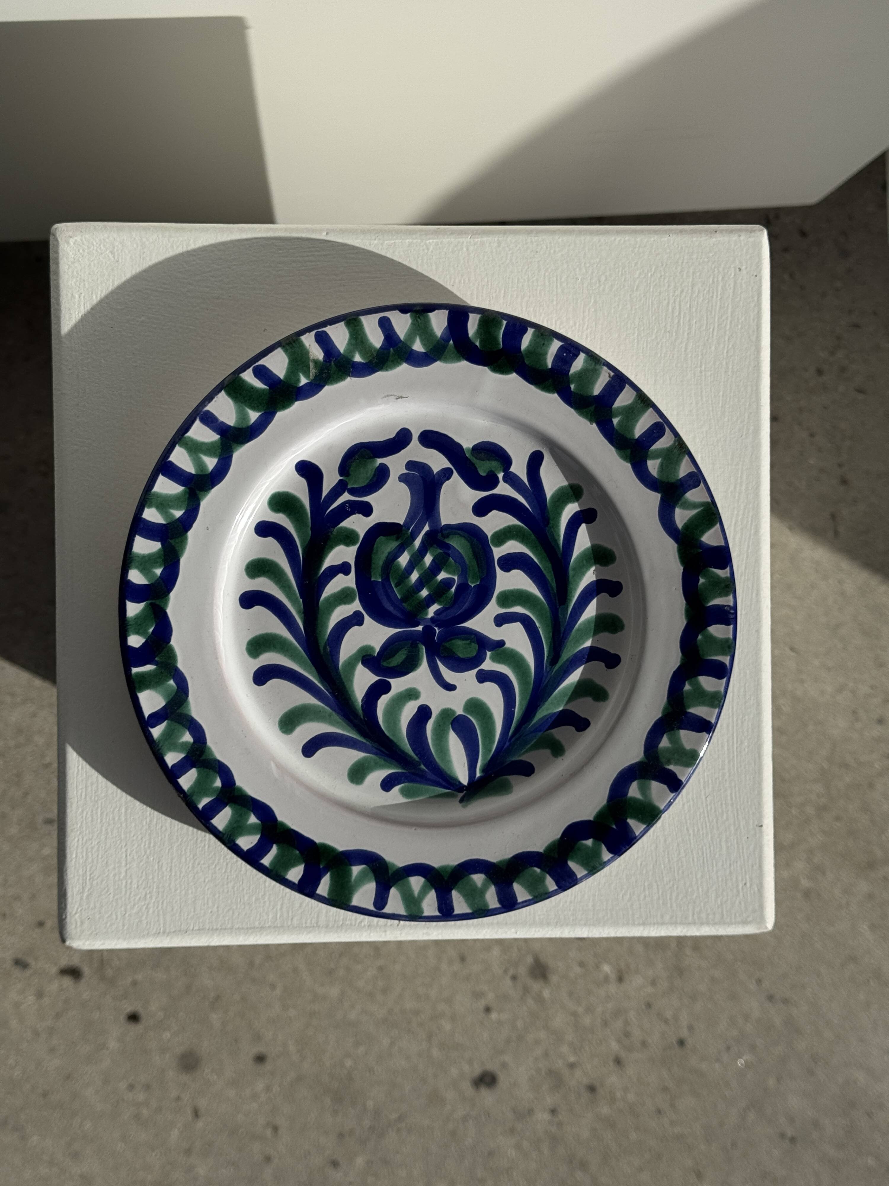 Artesania Alvarez Spanish plate in terracotta with blue plant motif.