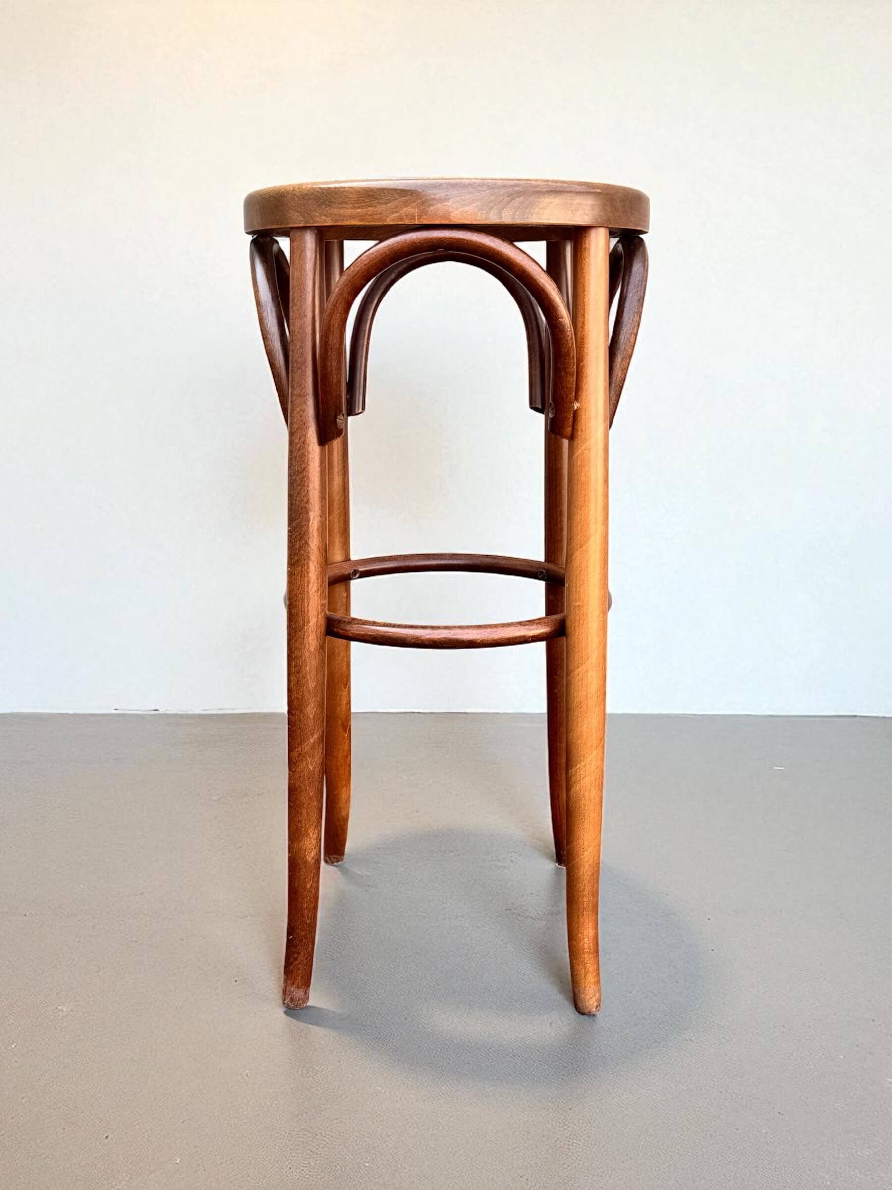 Old high stool in curved wood with caned seat