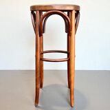 Old high stool in curved wood with caned seat