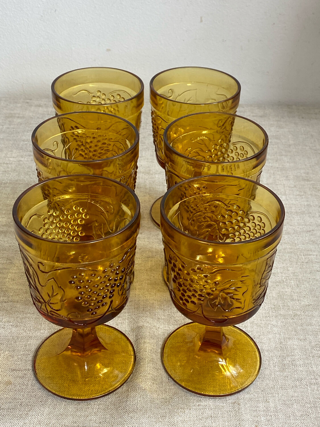 Six stemmed glasses in amber-colored molded glass