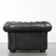 Set of a black cowhide leather Chesterfield armchair and matching ottoman