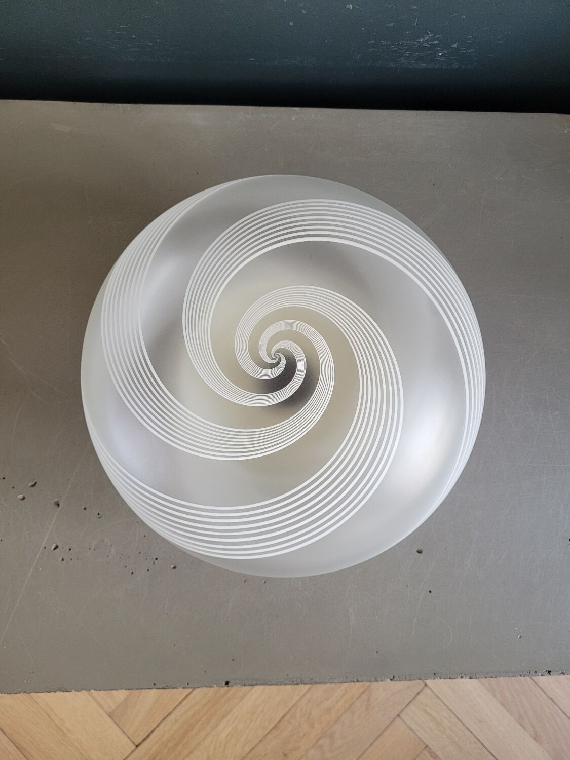 Frosted glass globe ceiling light with spiral patterns.
