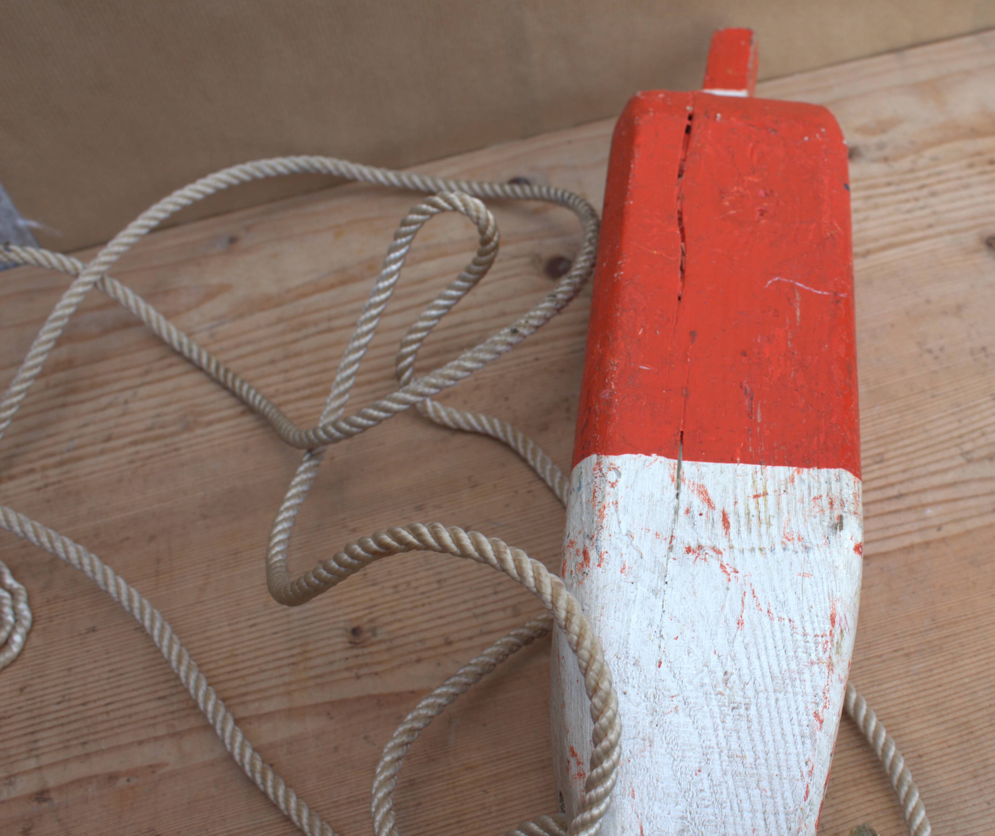 Old red and white wooden buoy