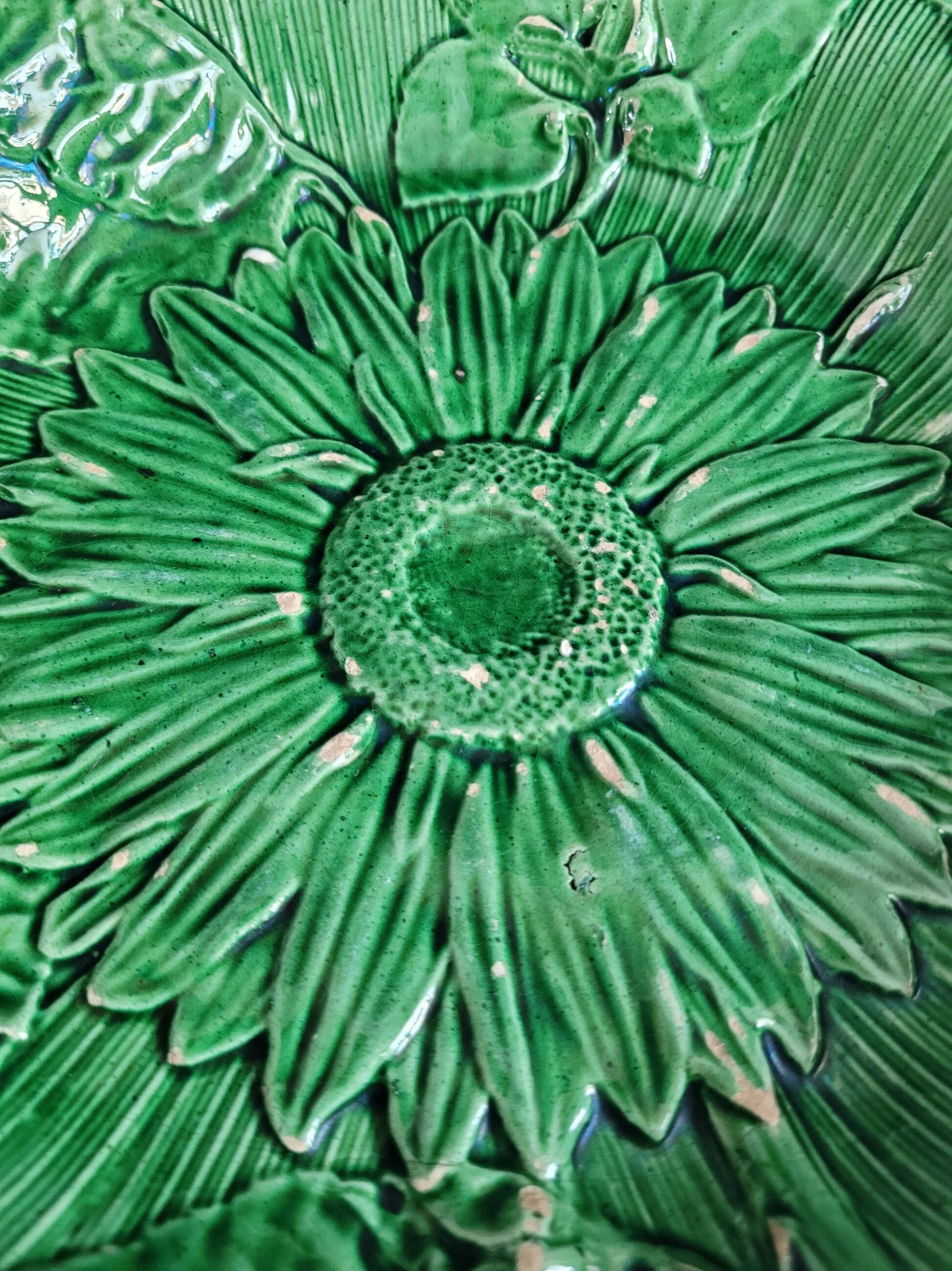 Plate decorated with a sunflower motif in slipware.