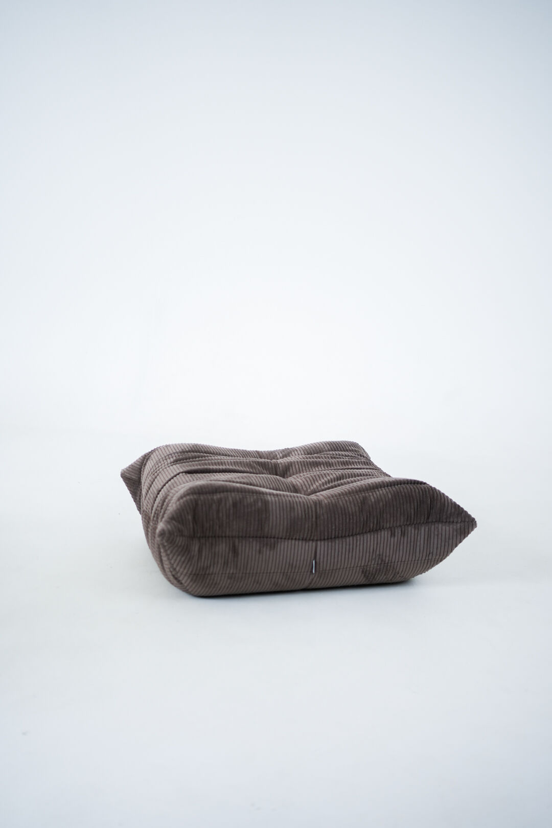 Ensemble de chaise et pouf Togo en velours côtelé marron.