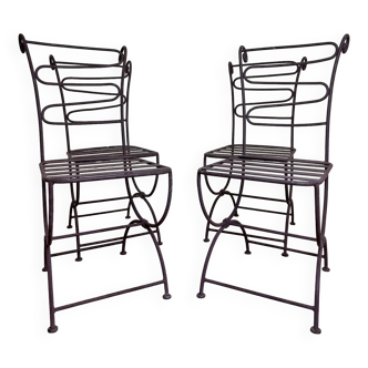 Series of four designer cast iron chairs with reversed backs and very beautiful x-legs