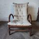 Relaxed armchair in bamboo and rattan with its small side table. Beige linen cushion.