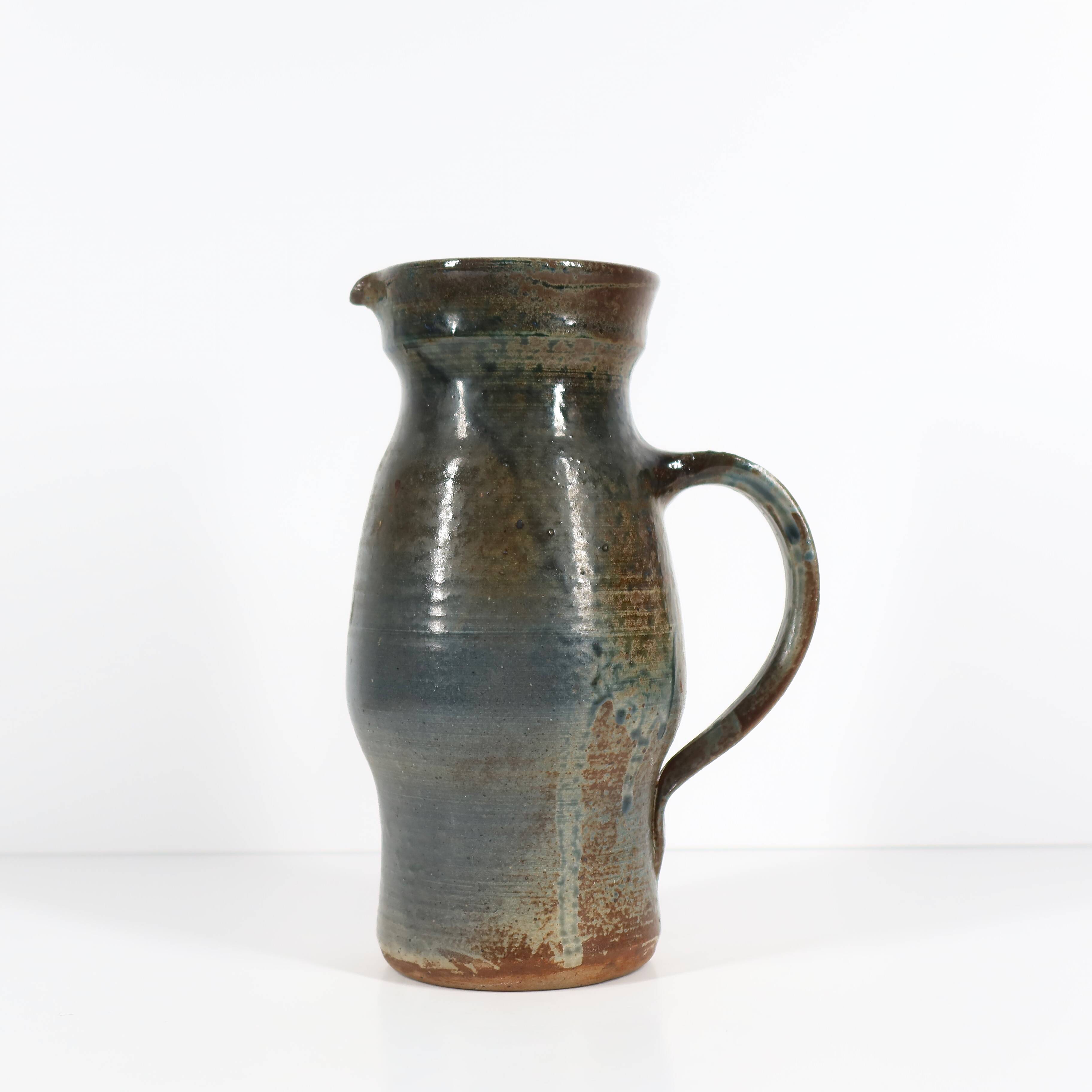 Handcrafted stoneware pitcher with blue-green hues, signed piece