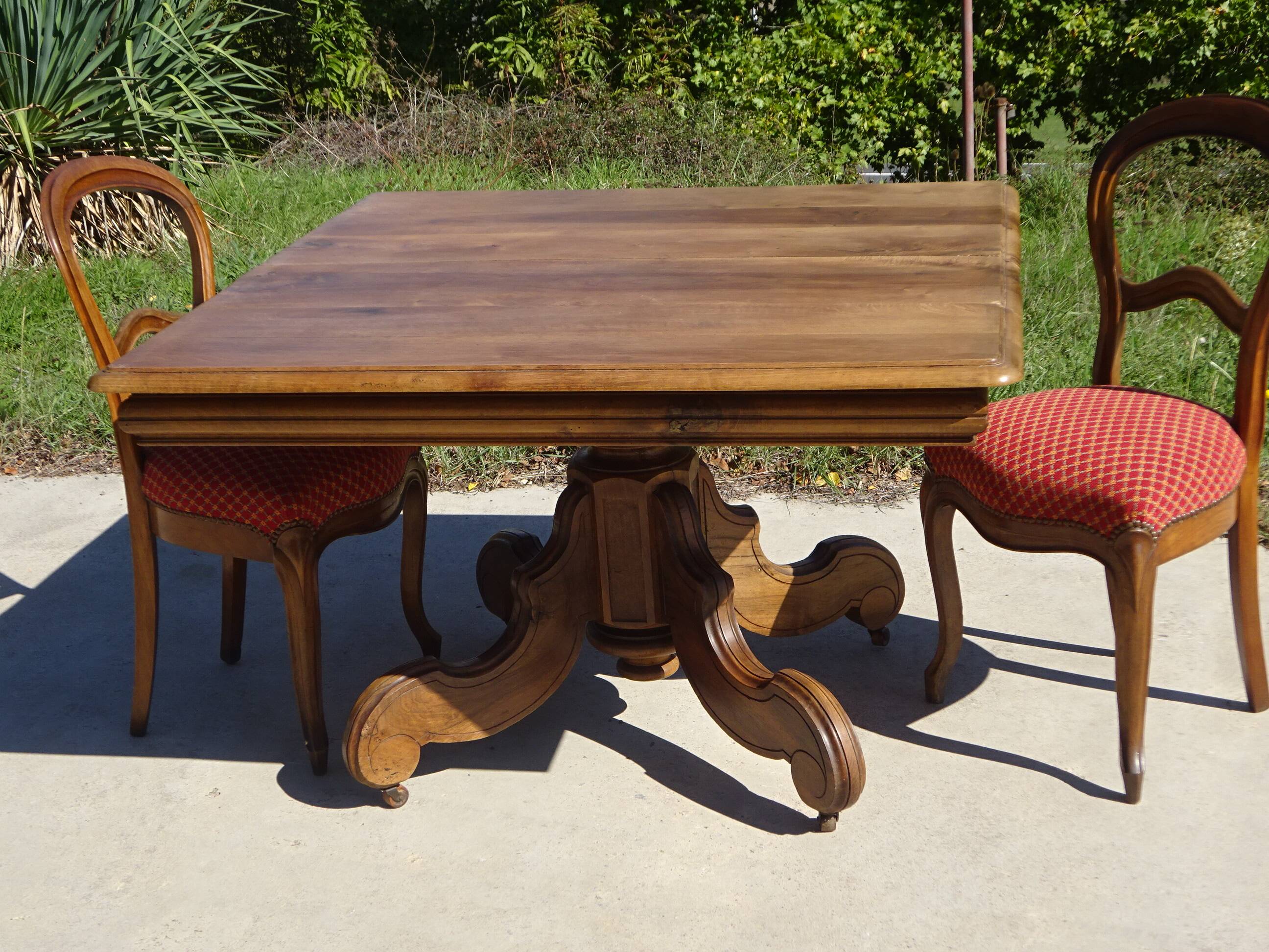 Old walnut table with a central leg.