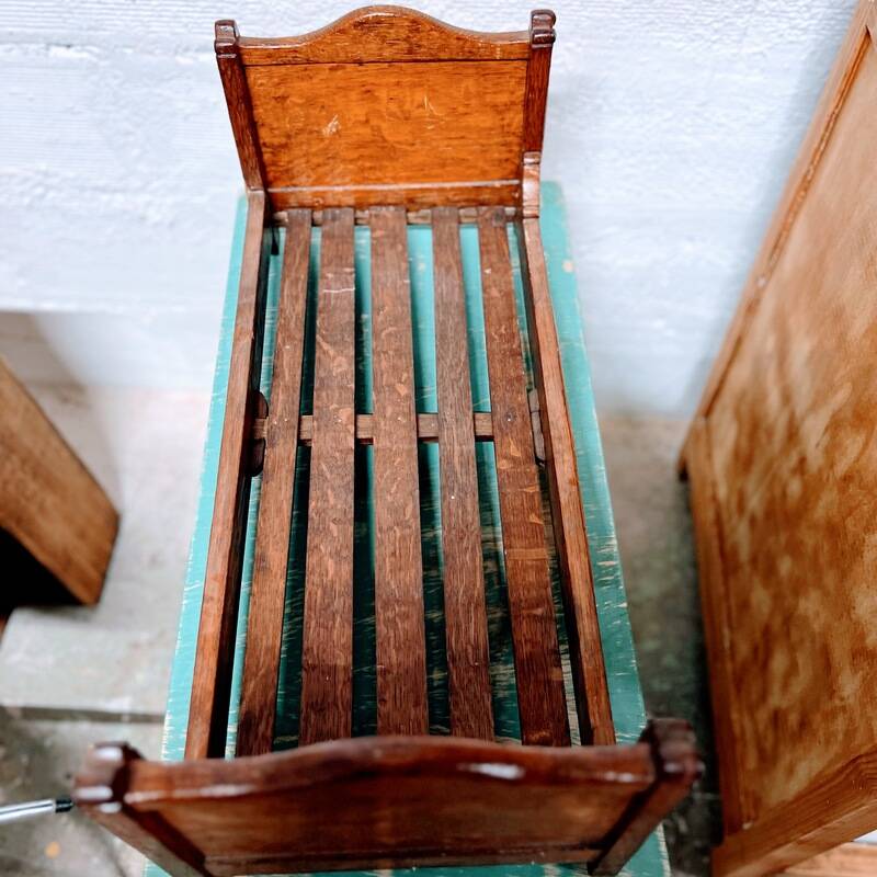 Old doll's bed in varnished wood