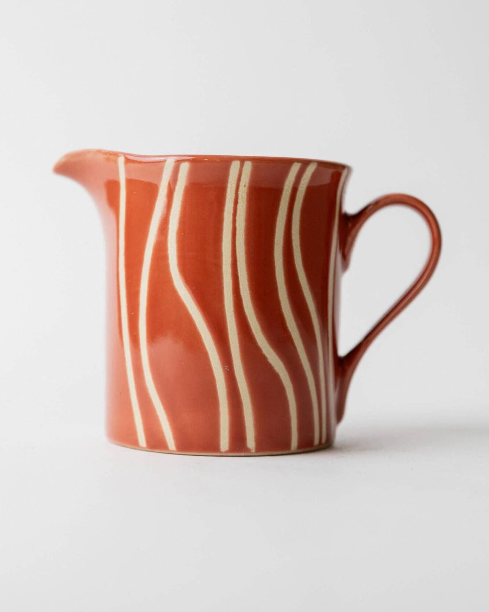 Vintage tea or coffee service in 1970s ceramic, teapot with lid and milk jug, rust orange with retro striped pattern, mid-century decoration, gift idea.