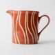 Vintage tea or coffee service in 1970s ceramic, teapot with lid and milk jug, rust orange with retro striped pattern, mid-century decoration, gift idea.
