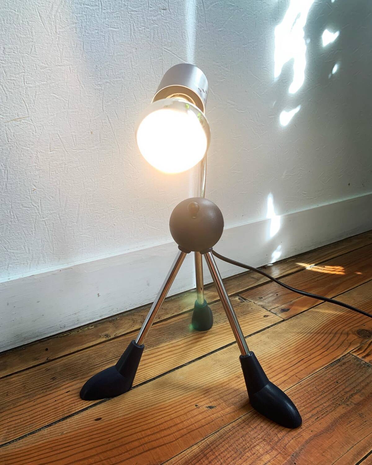 Articulated tripod foot lamp inspired by the Memphis movement