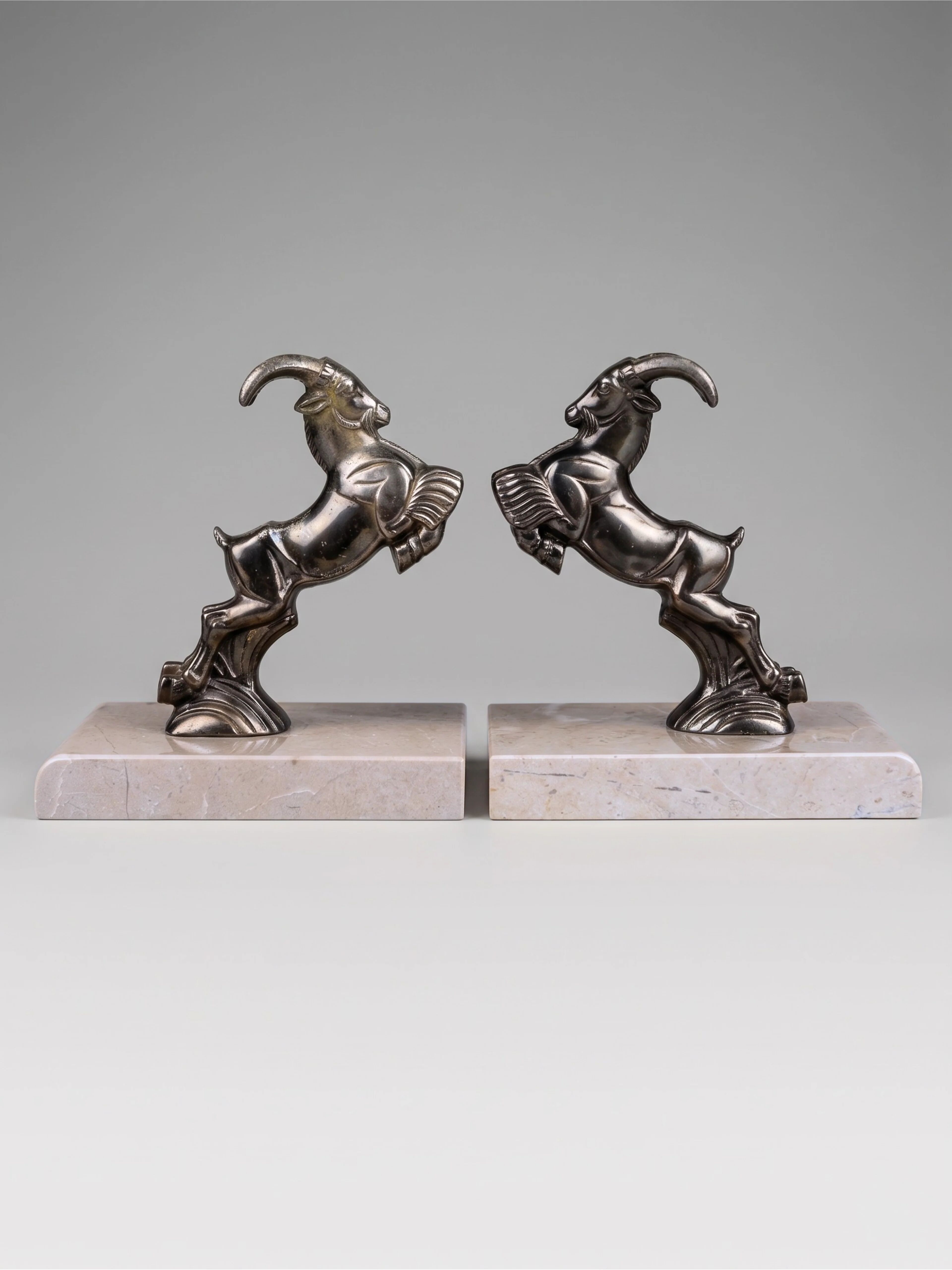 Art Deco bookends with patinated ibex in a taupe marble base.