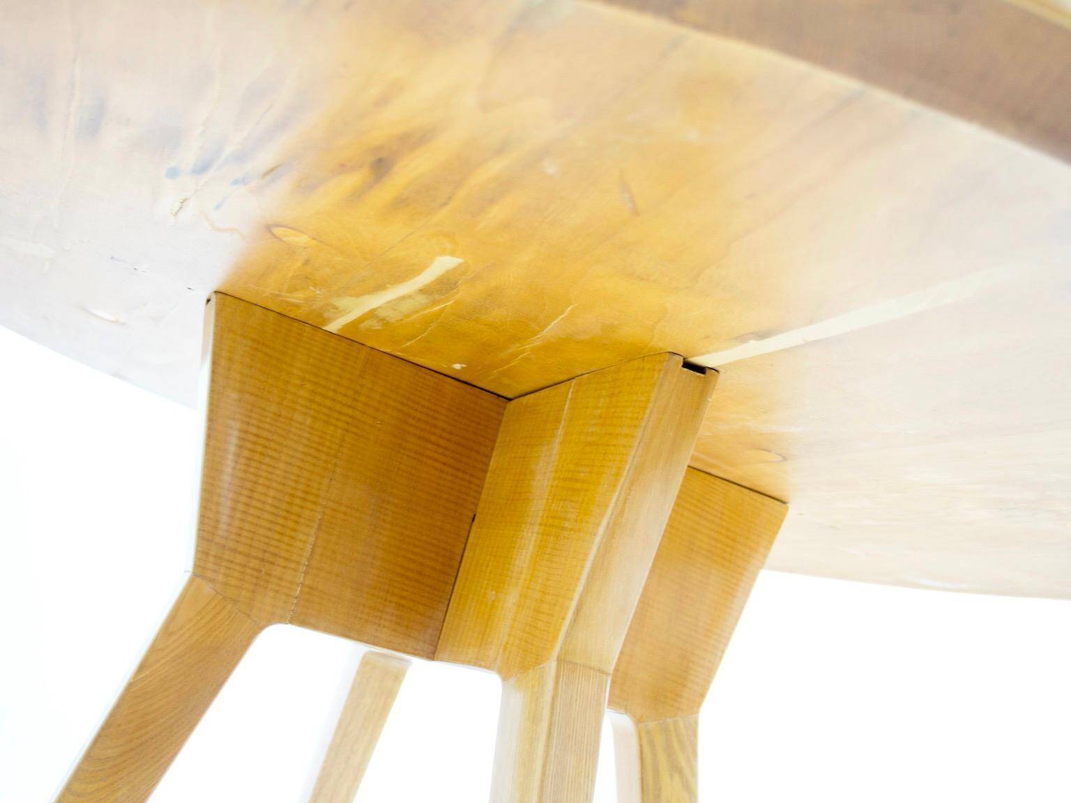 Round dining table in Wood Wood with brass details.