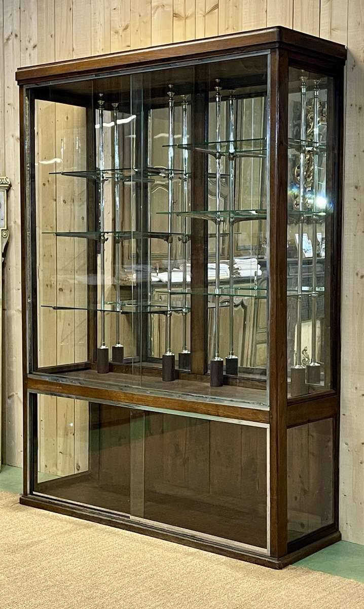 Early 20th-century shop display cabinet in oak with sliding doors.