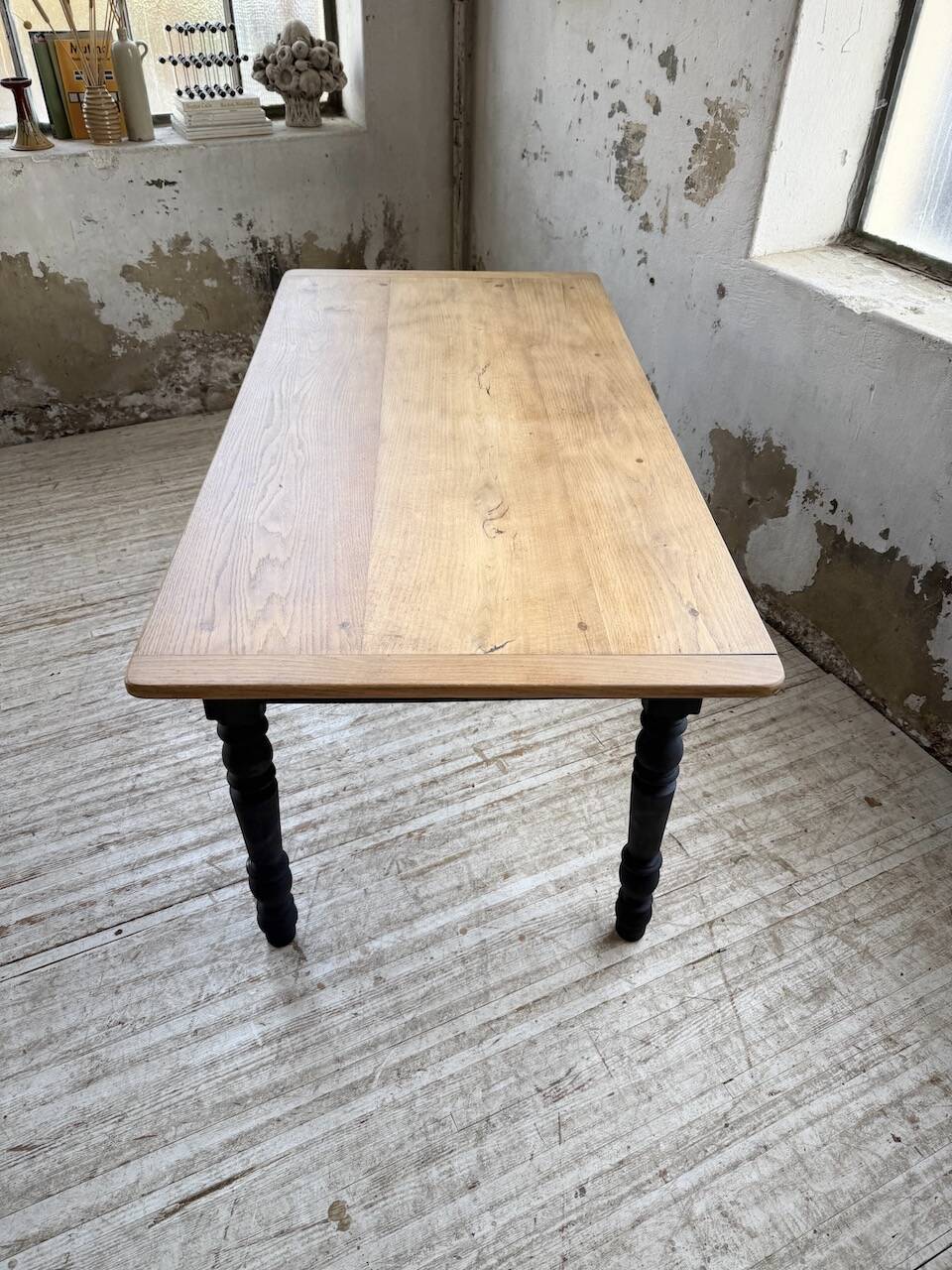 Oak farmhouse table with turned black legs.
