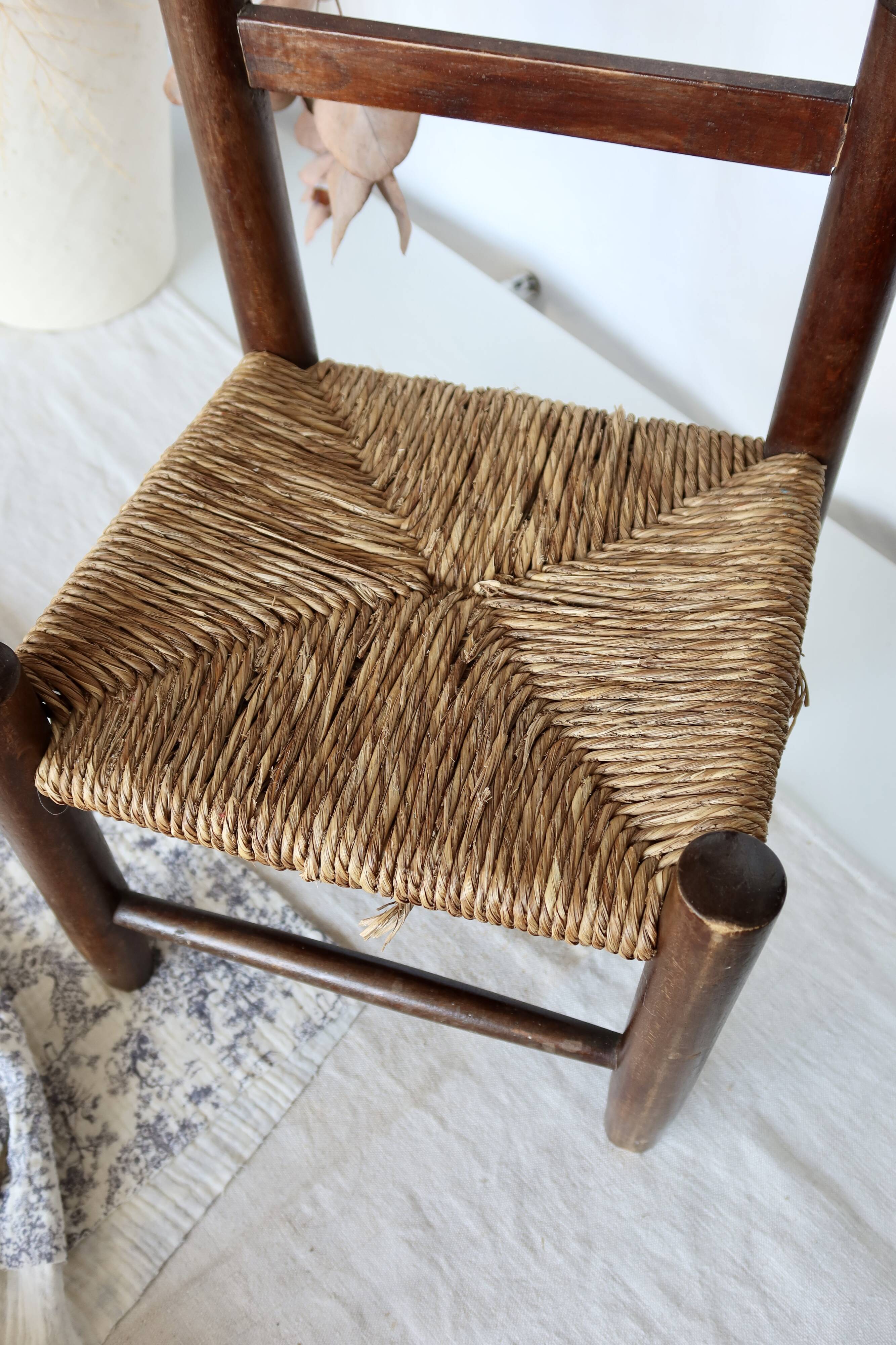 Vintage children's chair in dark wood with woven straw seat