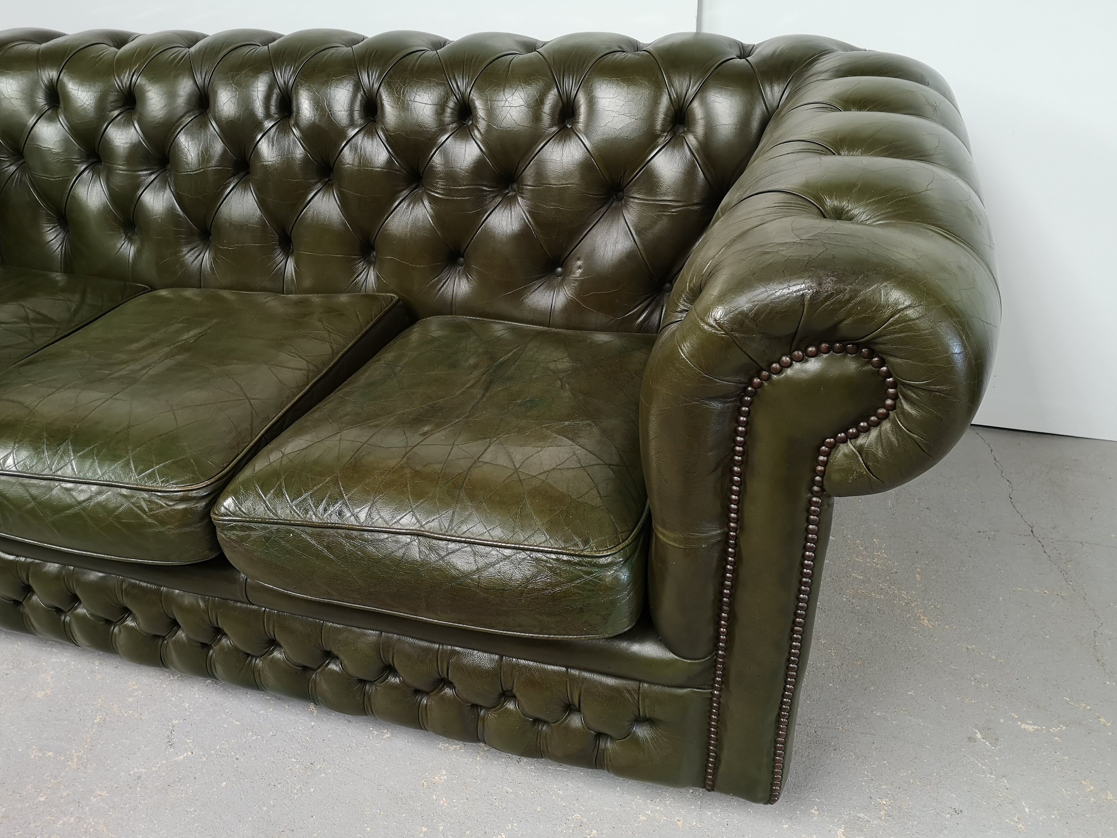Three-seater green leather Chesterfield sofa