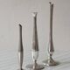 Set of three lightweight silver-coloured metal vases.